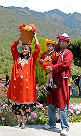 Tourists dressed in traditional Kashmiri attire pose for a photograph in Srinagar