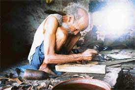 Pahar Singh, who specialises in making Punjabi �juttis�, busy at work in his shop at Alamgir village