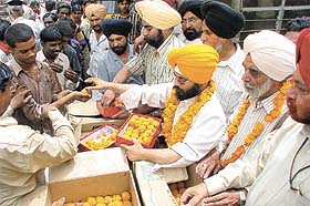 Members of New Rohtak Road Manufacturers Association along with Congress leader Paramjeet Singh Pamma, distributing sweets as Dr Manmohan Singh becomes the first Sikh Prime Minister 