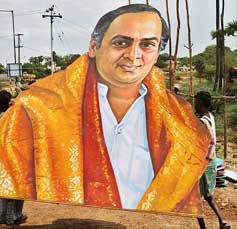 Labourers carry a portrait of former Prime Minister Rajiv Gandhi