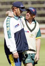 Australian cricketers Shane Warne and Damien Martyn talk during a practice session 