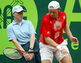 German tennis star Rainer Schuettler throws down his racket as a linesman watches during a match against Chilean Nicolas Massu 