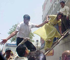 Rescuers help a woman down a ladder