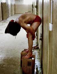 In this undated still photo, a hooded Iraqi detainee appears to be cuffed