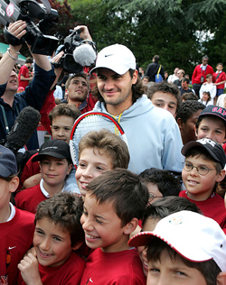 Swiss tennis star Roger Federer is surrounded by young fans after an exhibition training at Jean Bouin stadium in Paris