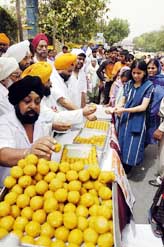 Sikhs distribute sweets to celebrate Dr Manmohan Singh's swearing in as Prime Minister in New Delhi on Sunday.
