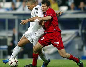 Real Madrid's Ronaldo of Brazil battles for the ball with Real Sociedad's Gabriel Schurrer