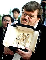 US director Michael Moore holds the Palme d'Or award for his documentary film Fahrenheit 9/11 