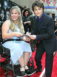 Actor Daniel Radcliffe, who plays the character Harry Potter, signs an autograph for Alexandra Carlson
