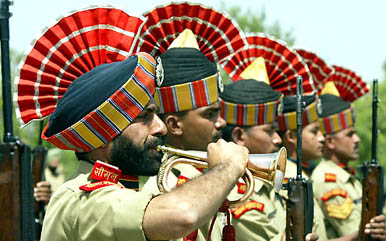 A BSF soldier blows his bugle as others pay respects during a wreath-laying ceremony for their colleagues at a camp in Humhama on the outskirts of Srinagar