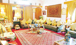 The living room and dining room are separated with an exquisitely painted Himachali palanquin.