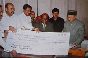 The Satluj Jal Vidyut Nigam Chairperson-cum-Managing Director, Mr Y.N. Apparao, presents a cheque for Rs 12 crore to the Himachal Pradesh Chief Minister, Mr Virbhadra Singh, in Shimla