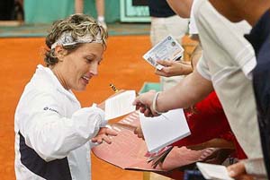 Tathiana Garbin of Italy signs autographs after defeating defending champion Justine Henin-Hardenne of Belgium