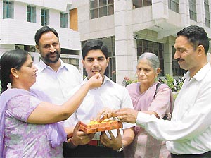 Varundeep, overall Class X CBSE topper from Ludhiana, being offered sweets by his mother on Friday.