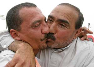 A former Iraqi prisoner kisses his relative after his release from Abu Ghraib prison