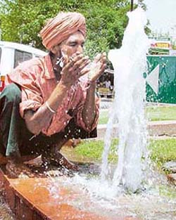 Water gushing out from a broken water-supply line near Aarti Chowk provides solace to a passer-by in the sweltering heat
