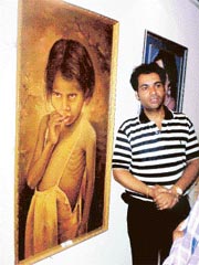 An artist with his paintings at an exhibition organised by North Zone Cultural Centre at Banasar Art Gallery