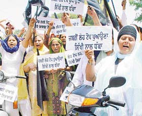 Sikh women participate in a scooter rally organised by various Sikh bodies in protest against wearing of helmets