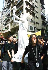 Hong Kong pro-democracy students carry a statue of the goddess of democracy during a protest march on Thursday to mark the 15th anniversary of Beijing's military crackdown on the pro-democracy movement at Tiananmen Square