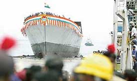 Dock workers watch the launch of Satpura, India�s second indigenously built Stealth Frigate, in Mumbai 