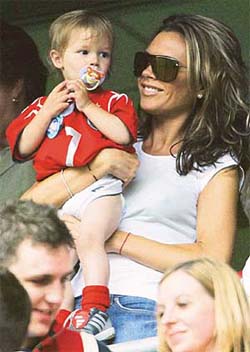 Victoria Beckham holds her son Romeo before England's three-nation tournament soccer match against Iceland in the City of Manchester Stadium in Manchester