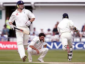 New Zealand's Chris Cairns holds his head as Andrew Flintoff and Geraint Jones run 