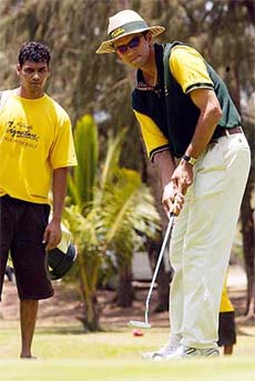Cricketer Rahul Dravid putts at the "celebrity golf" tournament in Mumbai