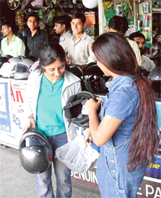 City girls looking at helmets in Chandigarh on Monday.