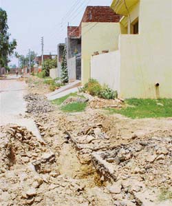 Mounds of earth and stone and dug up portions of a lane for laying water supply pipes obstruct entry to houses in Dashmesh Nagar, Kharar