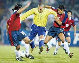 Brazil's Ronaldo fights for the ball against Chile's Rodrigo Melendez and Ricardo Rojas in the first half of their World Cup qualifying match at the National Stadium in Santiago