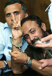 Handcuffed Palestinian uprising leader Marwan Barghouti, seen as a possible successor to Yasser Arafat, flashes the V-sign before he heard the verdict on his trial in the Tel Aviv District Court