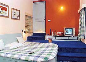 Bedroom with carpeted stairs leading to the bathroom