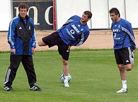 Greek team coach Otto Rehhangel walks by Dimitrios Papadopoulos and Theodoros Zagorakis right, during training in Vila Do Conde