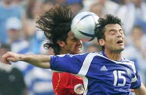 Greece�s Zisis Vryzas is challenged by Portugal�s Fernando Couto during their Euro 2004 Group A match at the Dragao Stadium in Porto 