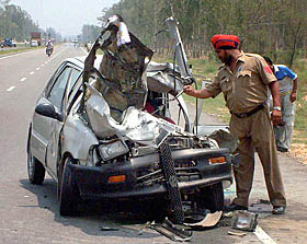 A Punjab Police cop checks the remains of the car