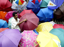 loke Saha, an umbrella seller, waits for customers in Kolkata
