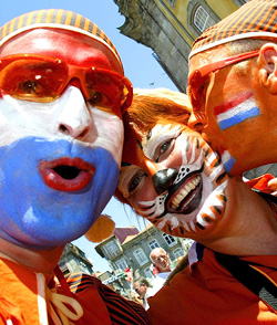 Three Holland fans smile before the start of their Group D soccer match