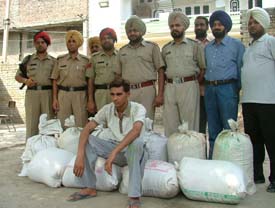 A narcotic smuggler with sacks of poppy husk seized from him in Ludhiana