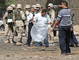 An Iraqi medic searches for body parts after a car bomb explosion outside a recruiting centre in Baghdad