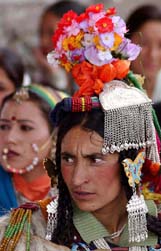 A woman in traditional Ladakhi headgear watches a cultural programme