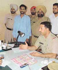 Inspector Sandeep Sharma shows the money recovered from a cheat, Banarsi Gupta