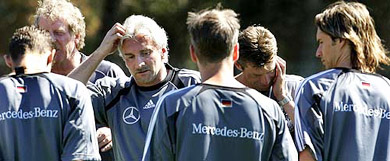 Germany team head coach Rudi Voeller and assistant coach Michael Skibbe talk to their players during a training session near Faro