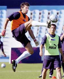 Italy's goalkeeper Gianluigi Buffon leaps in the air to kick the ball during a training session in Lisbon