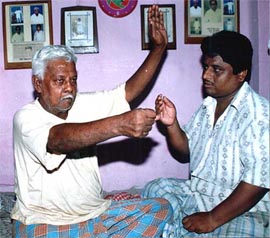 Hangman Nata Mallick demonstrates the process of hanging a convict to his son, Mahadev Mallick, at his residence in South Kolkata on Tuesday. Nata will hang Dhananjoy Chatterjee on June 25 of a 14 year-old girl in December 1989. 