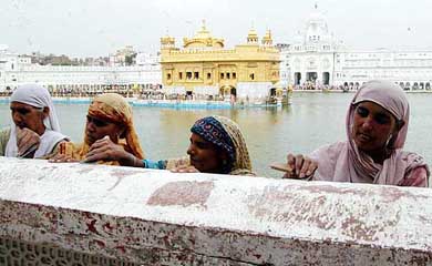 Devotees perform kar seva at the Golden Temple during the white-washing of the temple premises in Amritsar 