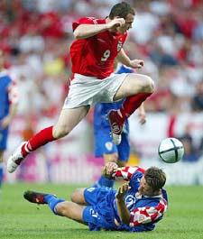 England's Wayne Rooney jumps over Croatia's Robert Kovac during the Euro group B match in Lisbon