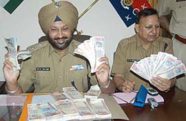 Police officers showing fake currency notes worth ten lakh recovered from four persons in Majitha of Amritsar district on Wednesday who used to make these using scanner, computer and printers. 