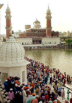 Devotees take a holy bath in the sarovar at the Golden Temple on the occasion of the 400th anniversary celebrations of the installation of Guru Granth Sahib on Wednesday. 