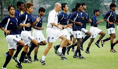 Indian football coach Stephen Constantine jogs with the players at a practice session in Kolkata on Tuesday