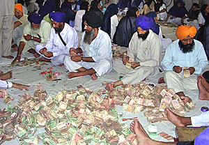 Employees of the SGPC count the money offered by devotees at the Golden Temple on the occasion of the celebrations of the 400th year of the installation of Guru Granth Sahib in Amritsar 